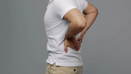 Man rubbing lower back in pain, backache