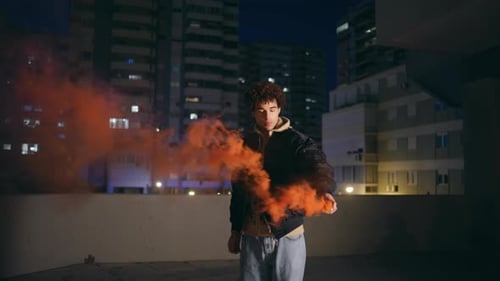 Hipster Holding Smoke Bomb at Night City Curly Guy Teenager Burning Red Grenade