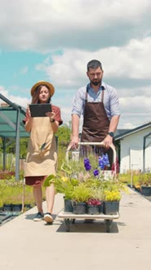 Gardeners Walking with Plant Cart at Garden Center