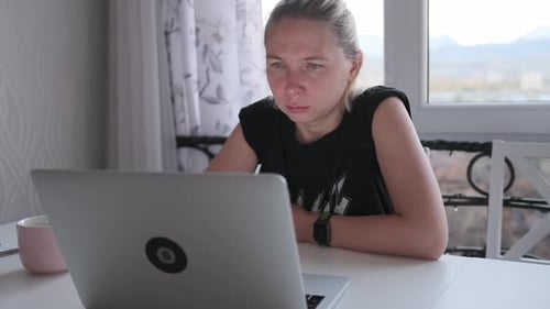 Woman Working On Laptop At Table Indoors