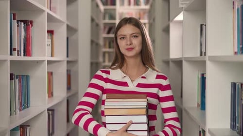 Student Holds Book Between Bookshelves
