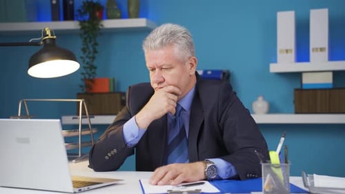 Thoughtful Man Working at Desk in Office