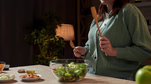 Woman Dances While Making Salad at Home