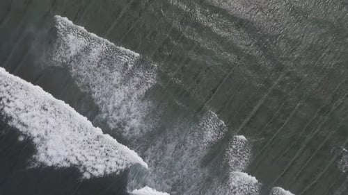 Aerial View of Waves Crashing on Sandy Beach