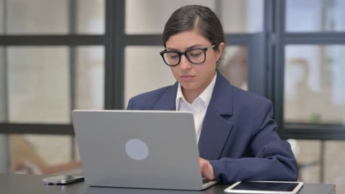 Smiling Woman Working on Laptop in Office