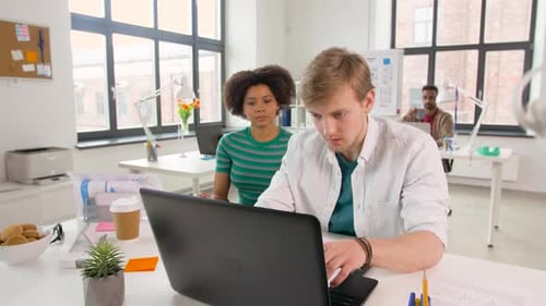 Creative team of designers and developers discussing user interface in modern office