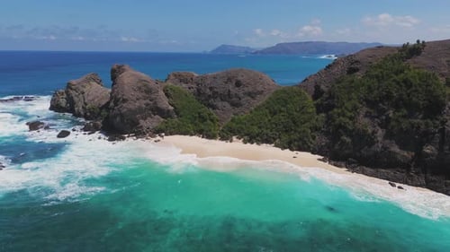 Aerial View of a Rocky Coastline with Turquoise Ocean Waves Crashing