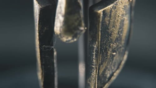 A close up detailed pan right shot of a spartan face design, warrior ancient greek bronze helmet, on