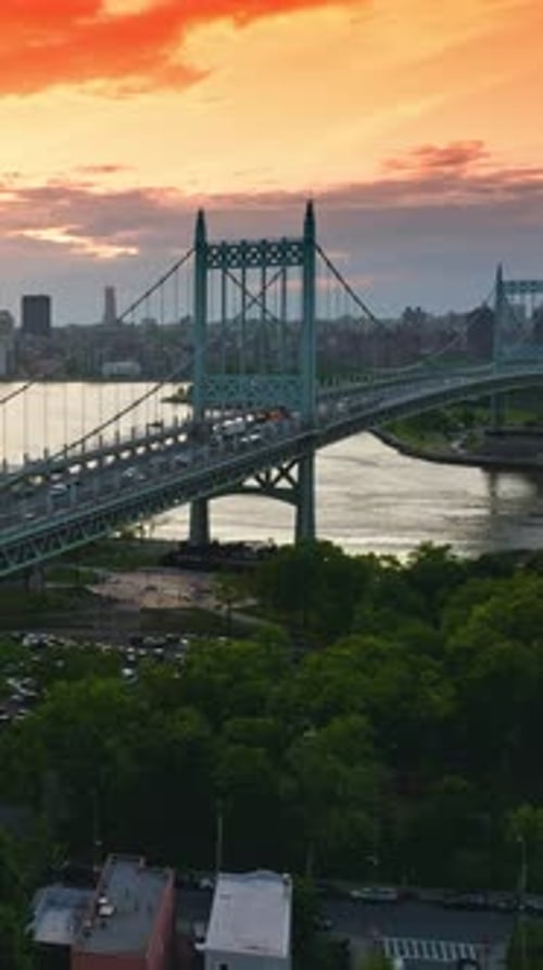 Marvelous bridge connecting green banks of the river. Busy traffic along the bridge.
