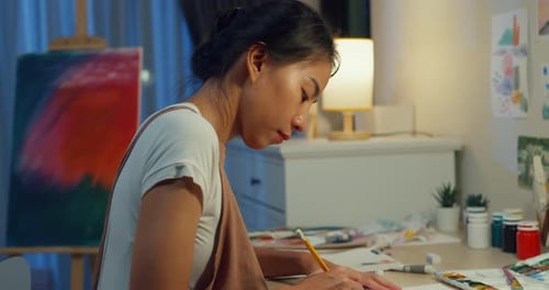 Asia lady drawing picture on sketchbook create artwork cozy workshop in home at night.