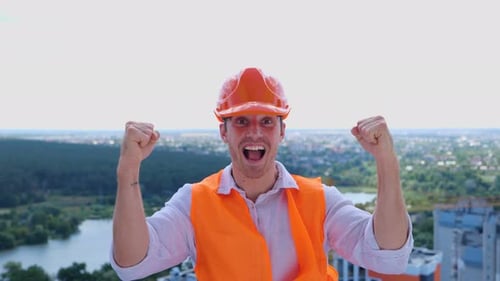 Construction Worker Cheering on Rooftop with City View
