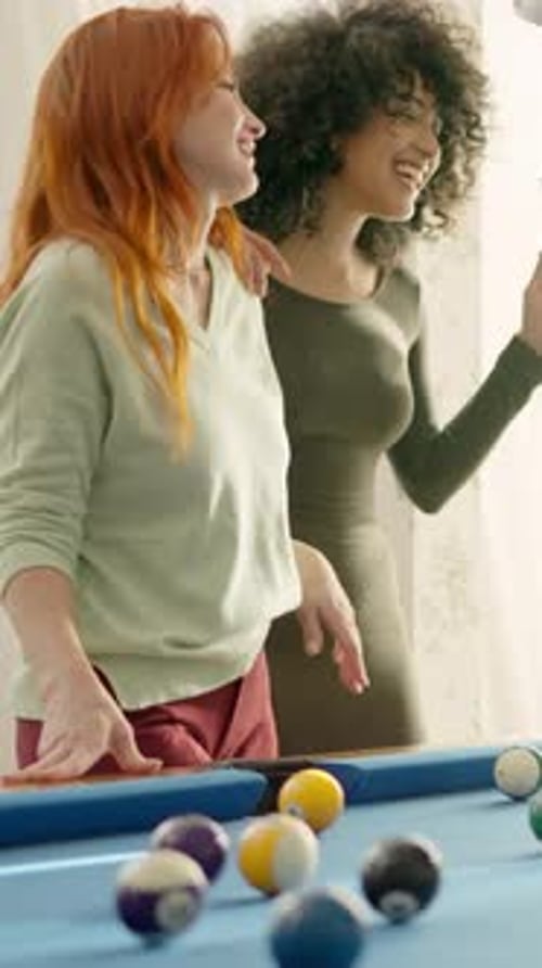 Friends Laughing While Playing Pool at Home