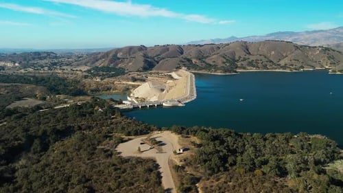 Aerial Wide View Over Water Reservoir and a Large Dam That Holds Water in California USA