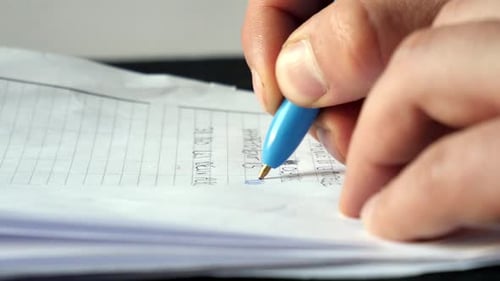 close up of a pen writing on paper