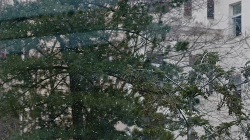 Schnee, der in Zeitlupe über Häusern im europäischen alten Stil mit Kaminen fällt