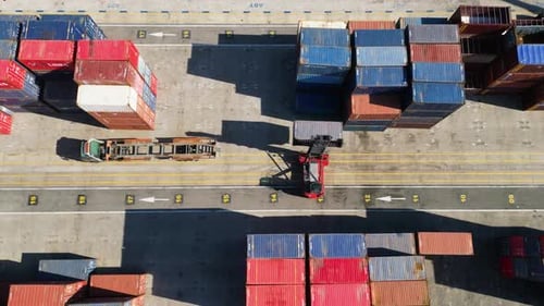 Luftaufnahme von oben auf Frachtcontainer und Gabelstapler im Hafen
