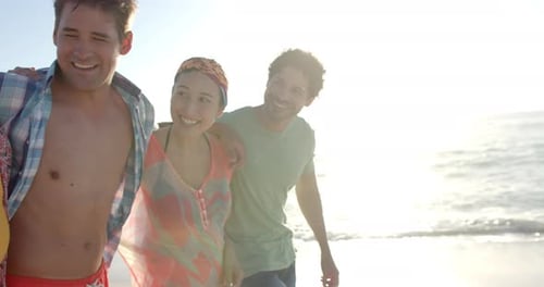 Diverse group of friends enjoying a sunny beach day, with copy space