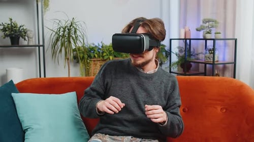 Man Experiencing Virtual Reality With VR Headset on Couch