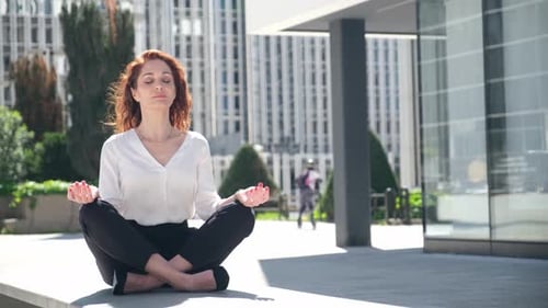 Red Haired Woman Meditating in an Urban Setting