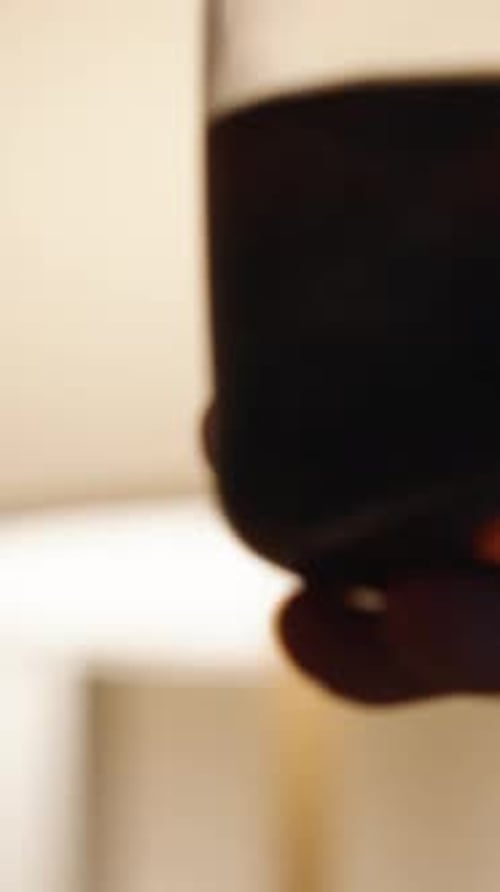 Hand Holding Wine Glass Filled With Beverage