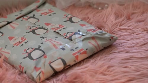Close-up of little girl wrapping birthday present or Christmas gift at home. Over Shoulder of child