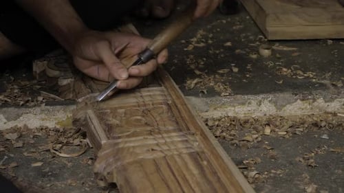 Craftsman Carving Intricate Designs Into Wood