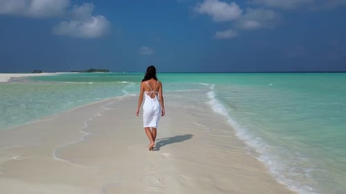 Young Woman in White Dress Walking Alone on Sandy Beach in Maldives Aeral Drone View
