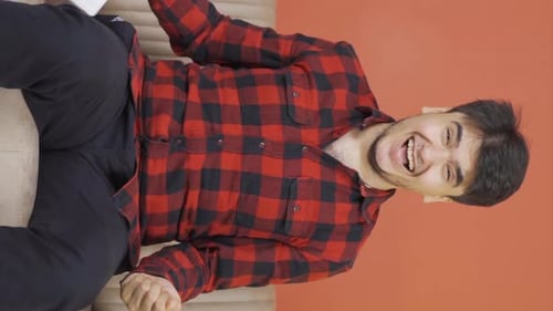 Young Adult Man Celebrates Good News Indoors