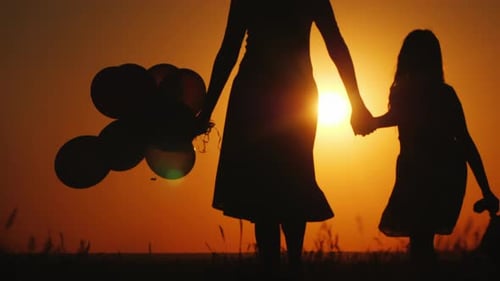 Mother and Daughter Holding Hands at Sunset