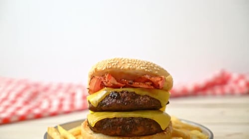 Double Cheeseburger with Fries Rotating on a Plate