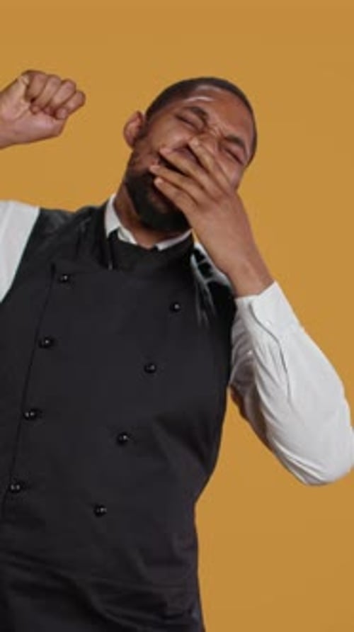 Vertical Video Tired Waiter Yawning and Stretching After a Night Shift and Feeling Exhausted