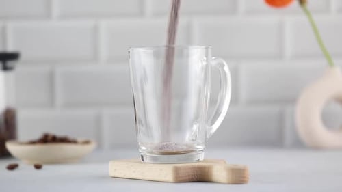 Powder Being Poured into Clear Glass Mug