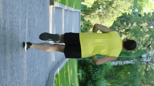 Vertical Screen Jogger Running in Summer Park in Slow Motion