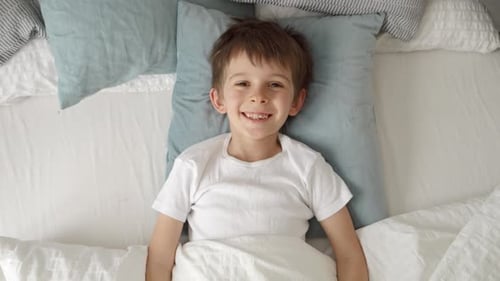 Boy Smiling, Lying in Bed