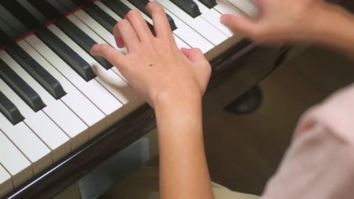 Close up of young child artist playing piano in a music record studio.