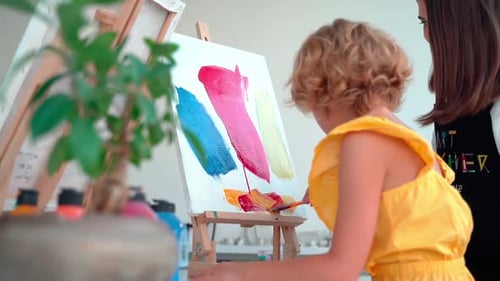 Teacher At Art School Helping Children in Art Class with Painting