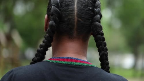 Serious African girl standing outside looking at camera