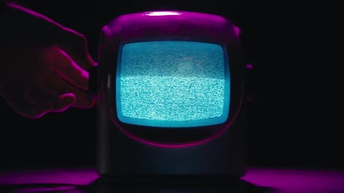Hand Turning Dial on Vintage Television with Static