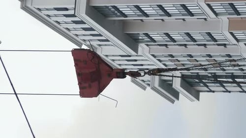 Tower construction crane carrying heavy materials at build site. Vertical video