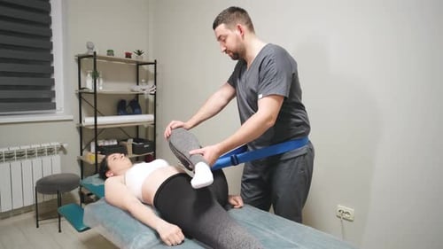 Professional Male Chiropractor Physiotherapist Treating Female Patient in Rehabilitation Center