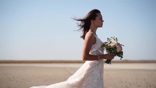 Happy Young Bride with Bouquet of Fresh Flowers Going at the Dry Lake Elegance Lady in Gorgeous