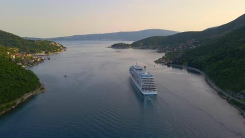 The Drone Captures a Stunning Aerial View of a White Cruise Ship Leaving the BokaKotor Bay in