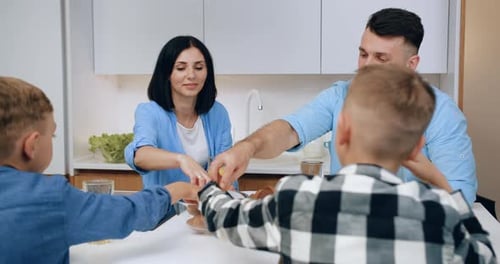 Family enjoying pastries together in kitchen