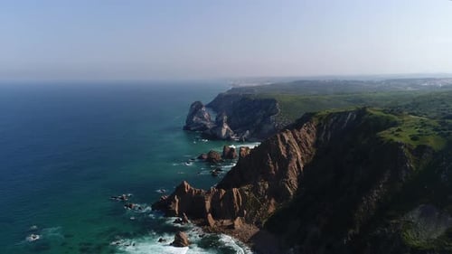 Flying over the Rock cliffs from Praia da Ursa beach on coast of Portugal