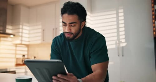 Man Using Tablet in Modern Sunlit Kitchen