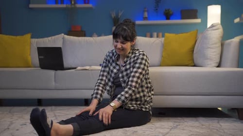 Woman Holding Knee in Pain Inside Living Room