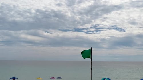 Ocean Waves and Beach Umbrellas on Cloudy Day