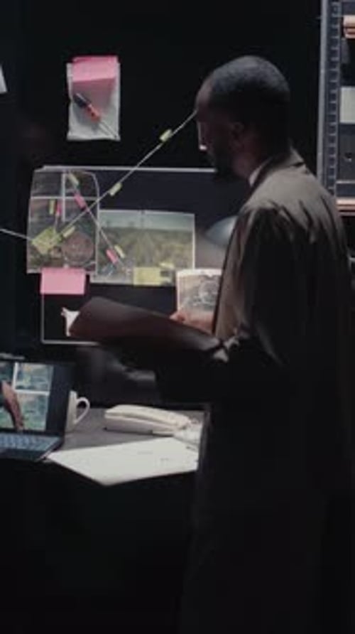 Investigators Review Evidence at Desk in Dark Room