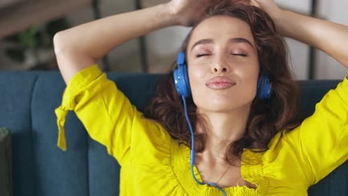 Woman Listening to Music, Relaxing on Couch