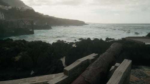 Waves crashing on the rocky coast of Garachico, old rusty cannon on Tenerife, Canary Islands